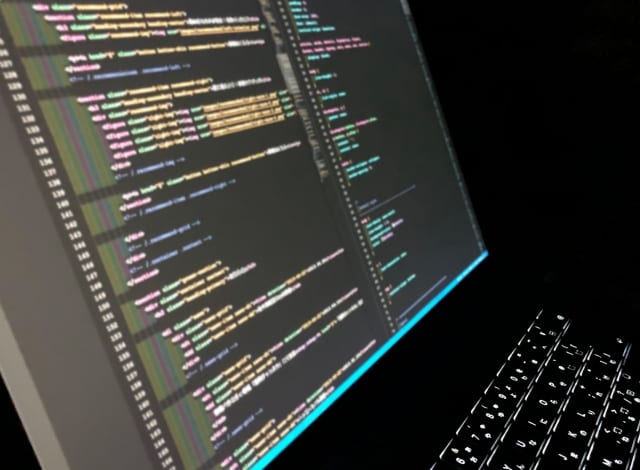 プログラムのソースコードが表示されたノートパソコンの画面